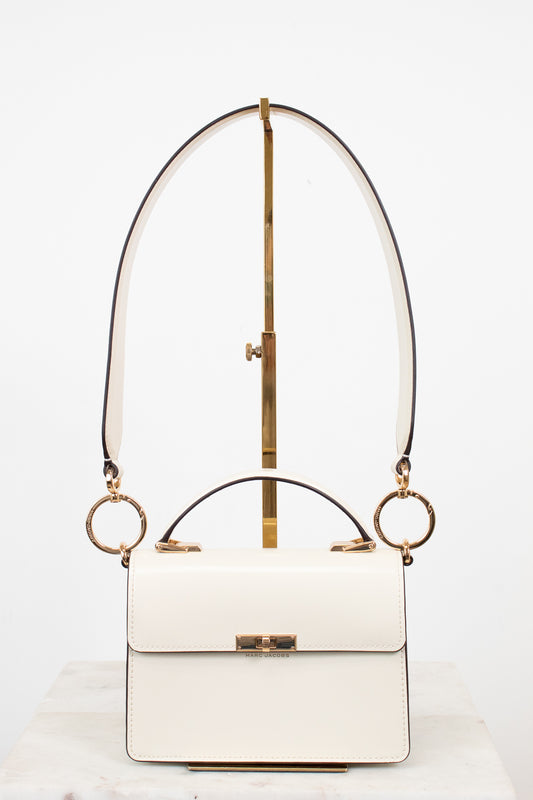 White handbag with gold accents on a white background