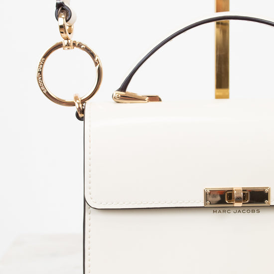 White handbag with gold accents on a white background