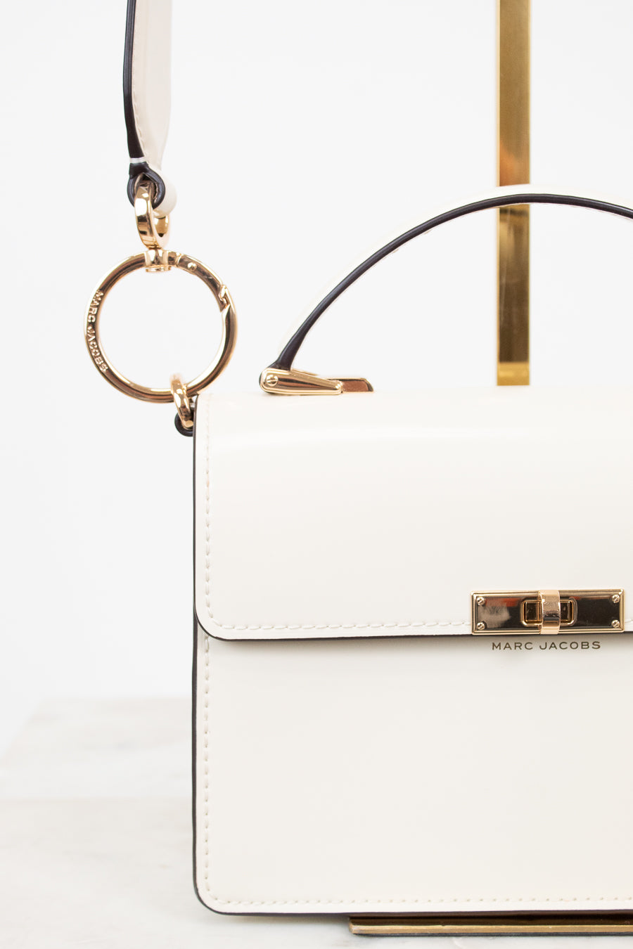 White handbag with gold accents on a white background