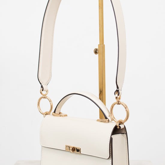 White handbag with gold accents on a white background