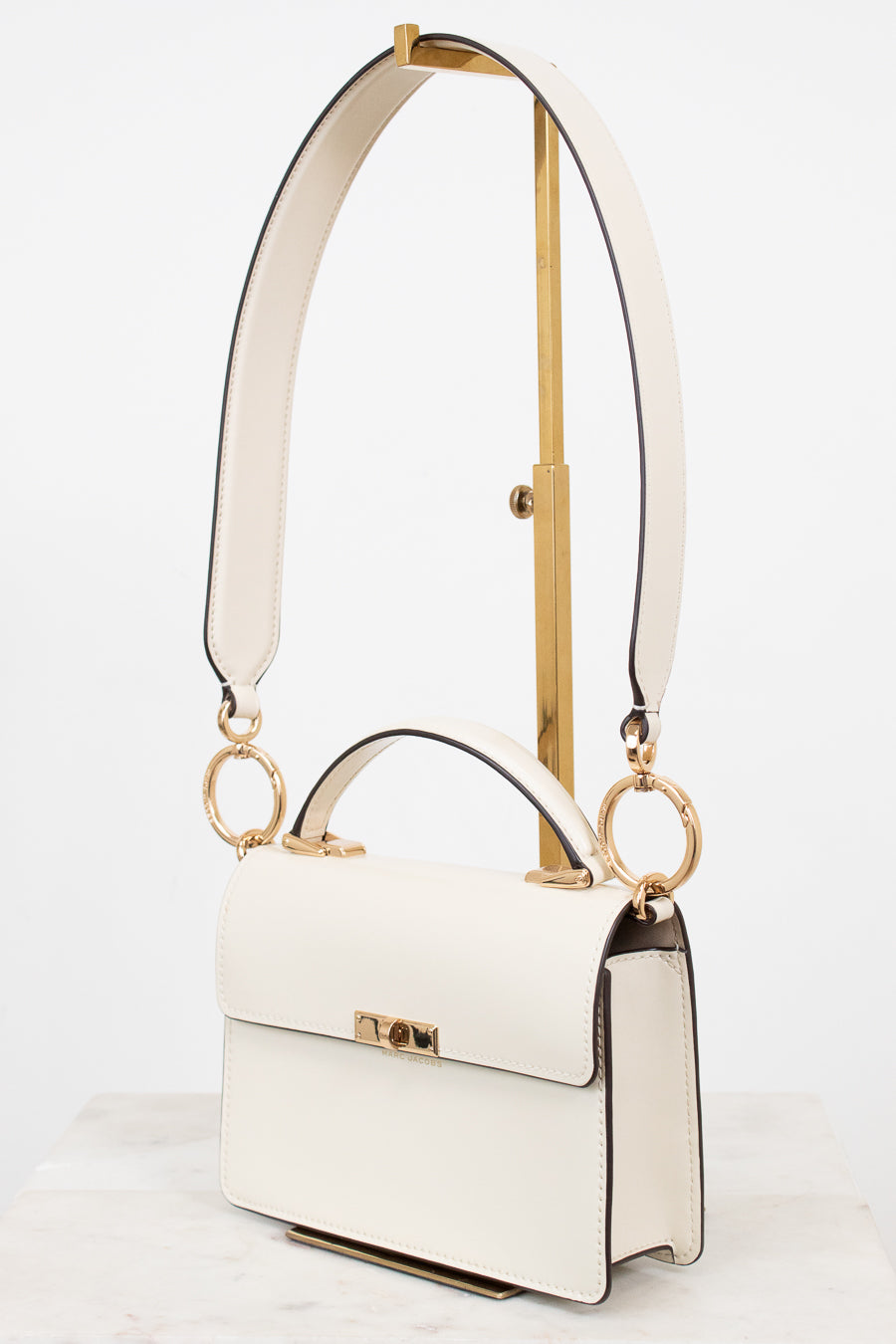 White handbag with gold accents on a white background