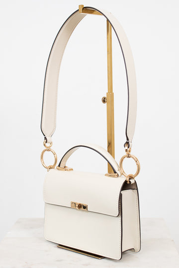 White handbag with gold accents on a white background