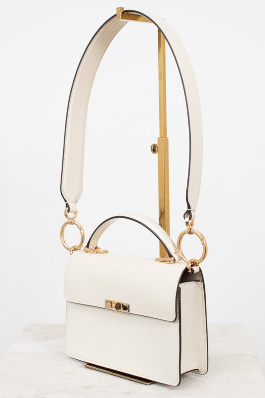 White handbag with gold accents on a white background