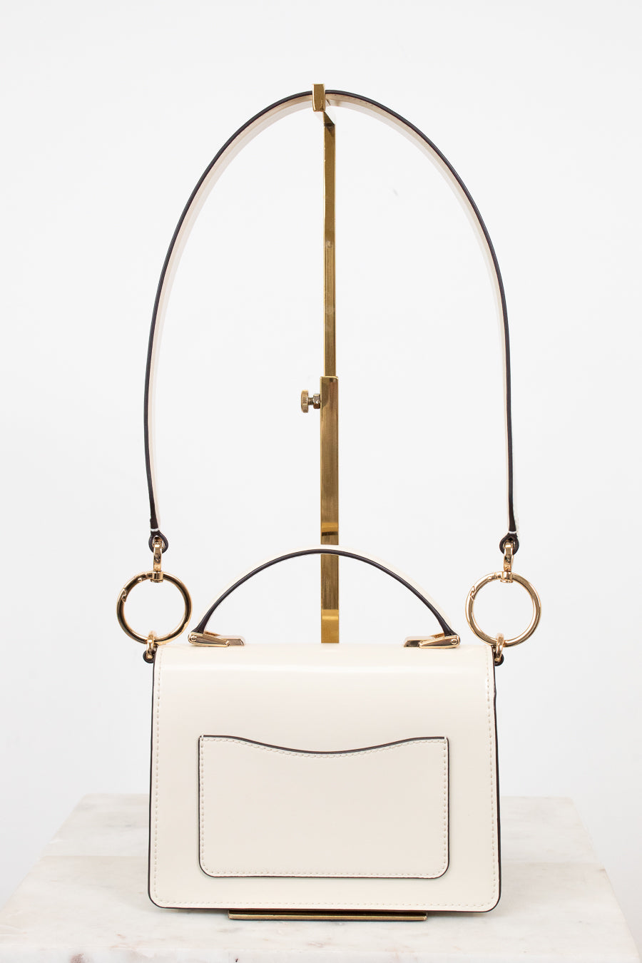 White handbag with gold accents on a white background