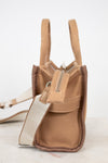 Brown side views of handbag with straps on a light background