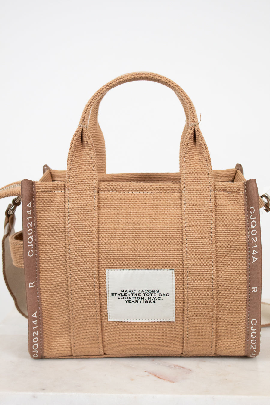 Brown handbag with visible branding on a white background