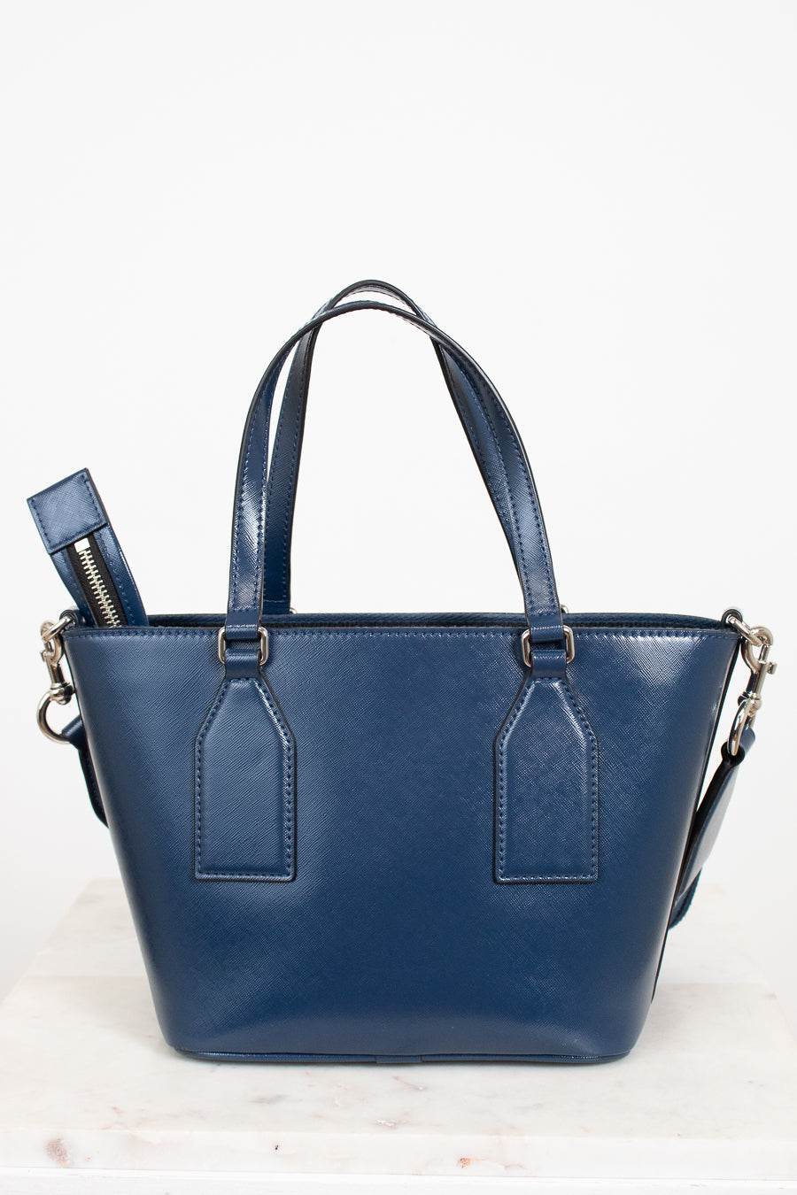 Blue leather handbag with a strap on a white background