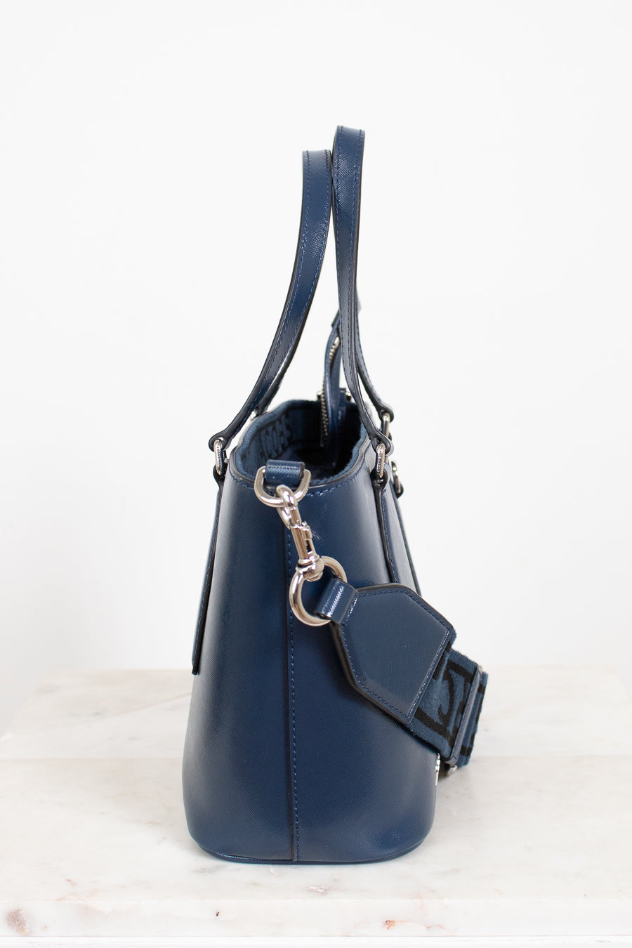 Navy blue handbag with a strap on a white background