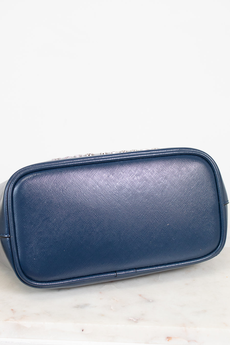 Blue base of handbag on a white marble surface