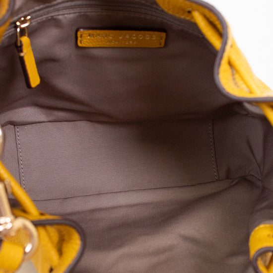 Close-up of interior of a yellow handbag with a visible brand logo on a white background
