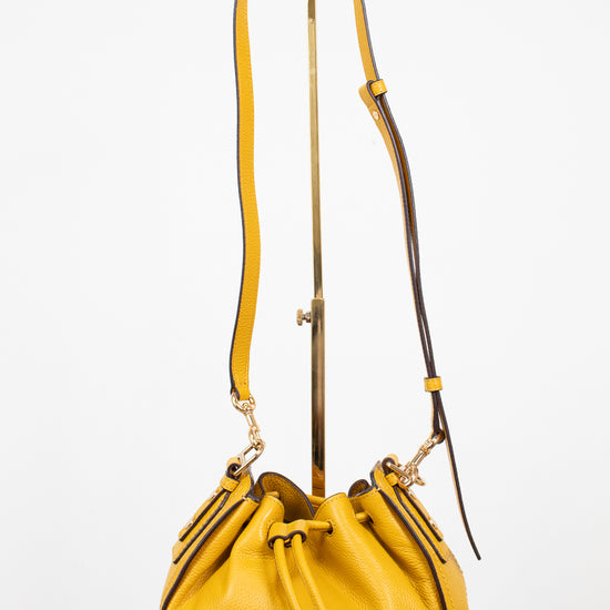 Yellow handbag with a strap on a white background