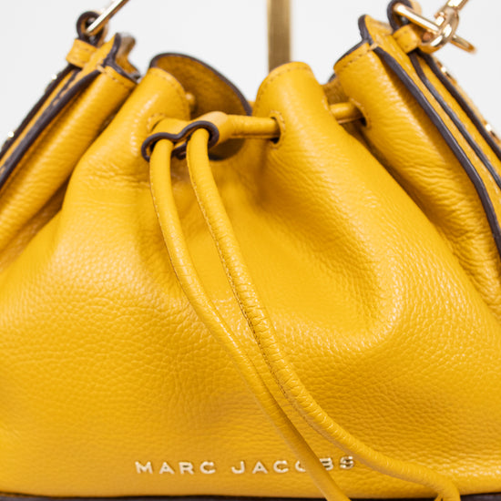 Yellow handbag with 'Marc Jacobs' branding on a light background