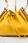 Yellow handbag with 'Marc Jacobs' branding on a light background