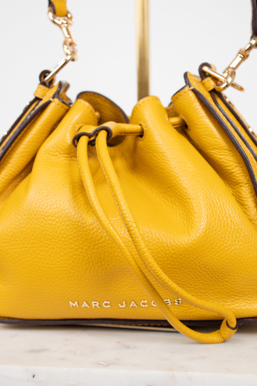 Yellow handbag with 'Marc Jacobs' branding on a light background