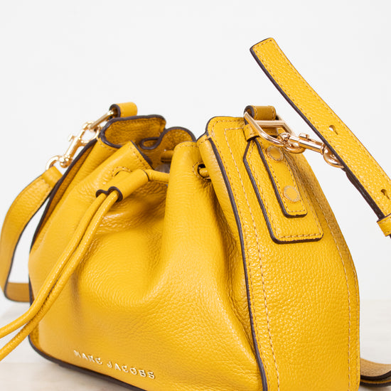 Yellow leather handbag with a strap on a white background
