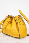 Yellow leather handbag with a strap on a white background
