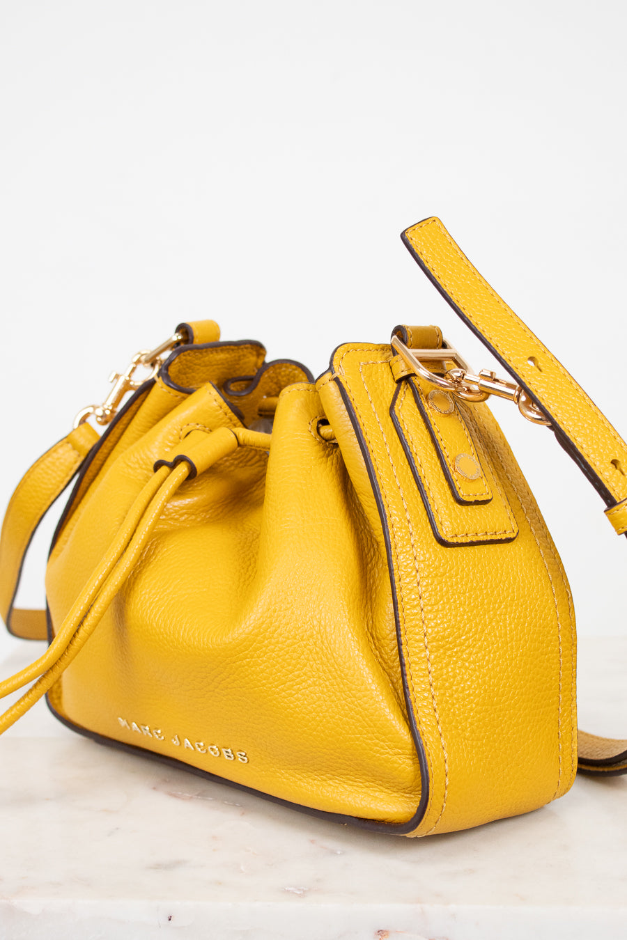 Yellow leather handbag with a strap on a white background