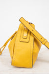 Yellow leather bucket bag with a strap on a light background