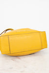 Yellow handbag with brand name on a light background