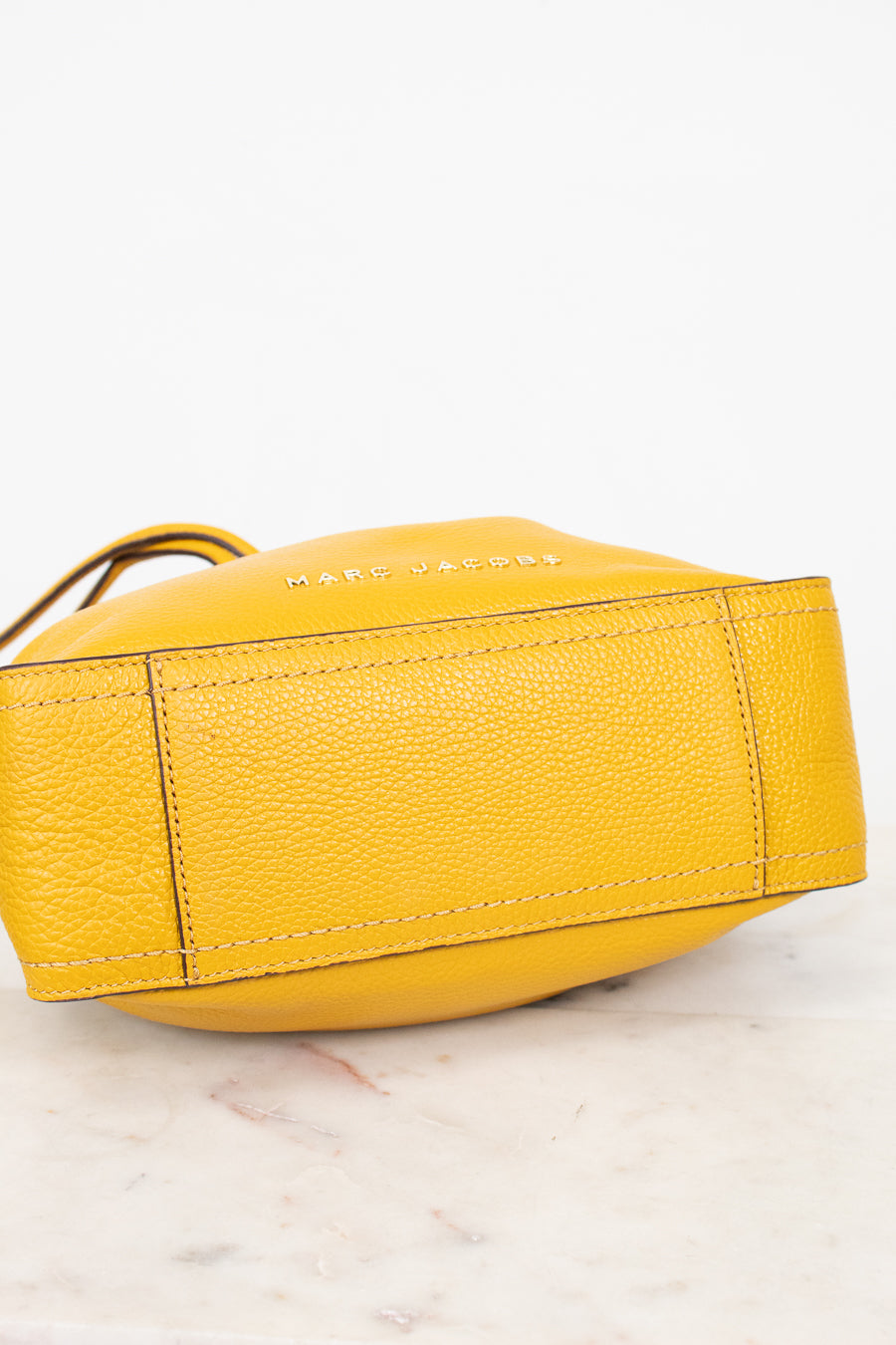 Yellow handbag with brand name on a light background