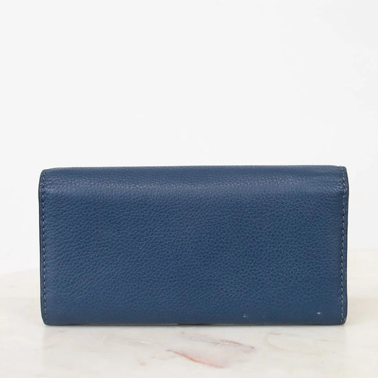 Back of Blue wallet on a white marble surface