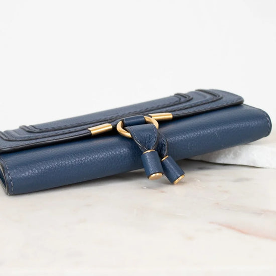 Blue clutch bag with gold clasp on a light background