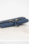 Blue clutch bag with gold clasp on a light background