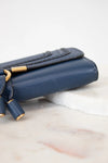 Blue handbag with gold accents on a marble surface