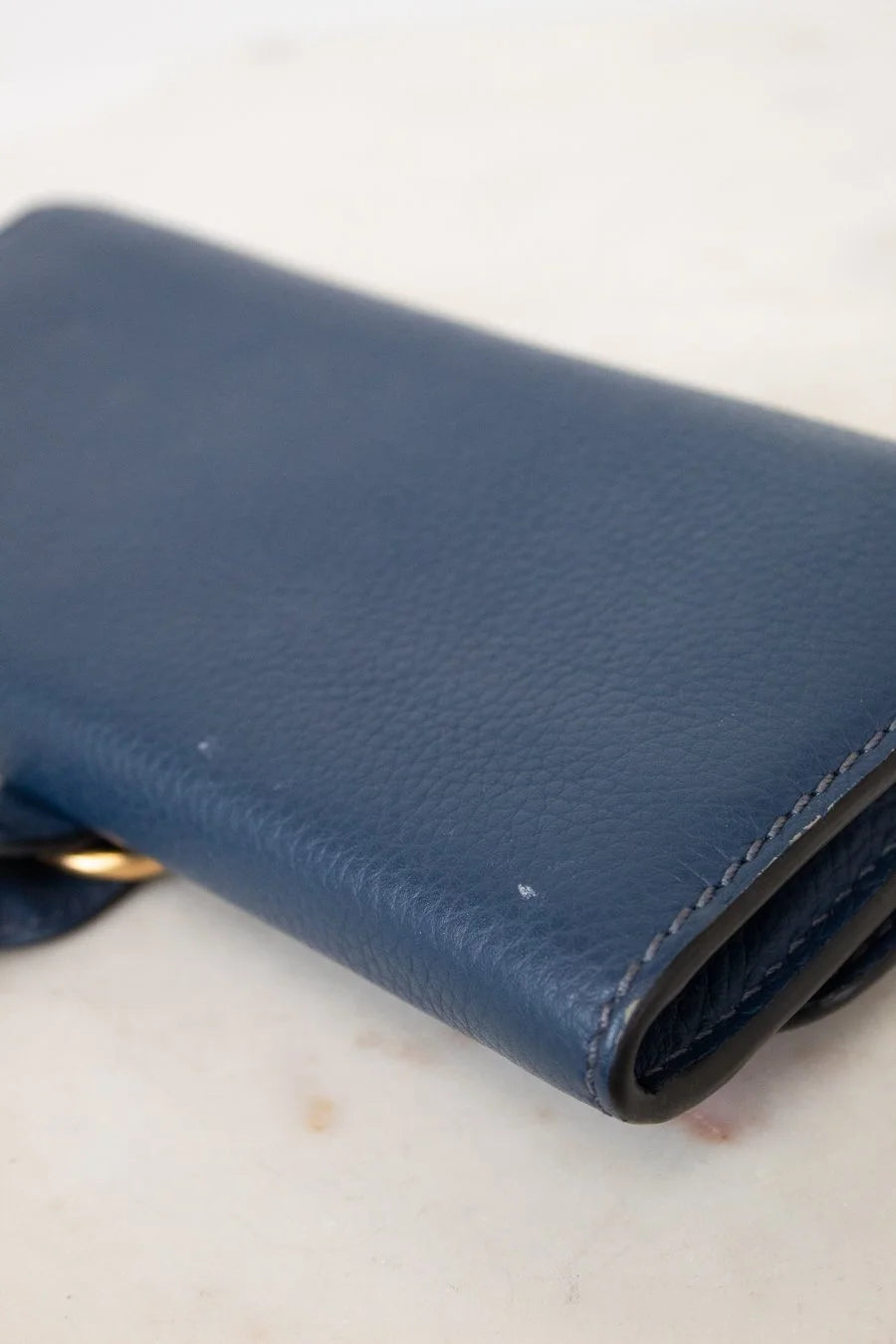 Blue leather wallet on a light marble surface