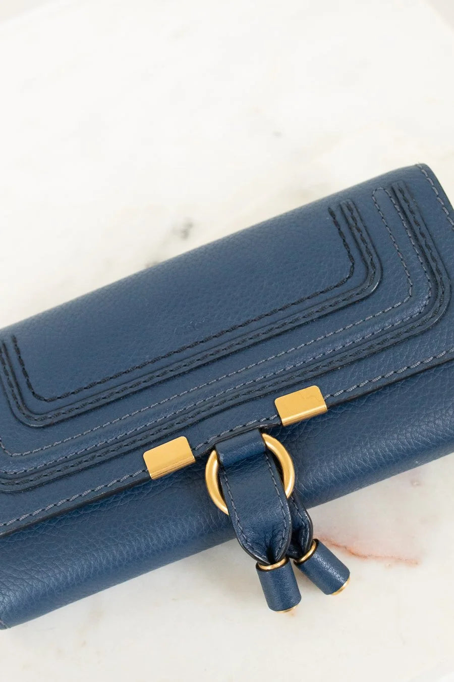 Blue wallet with gold accents on a light background