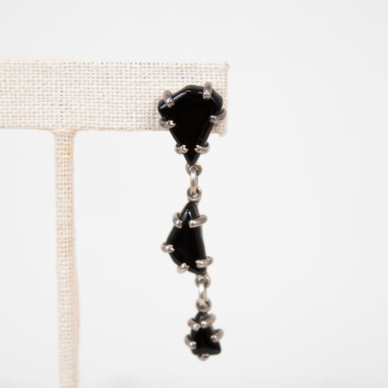 Black glass tiered earrings on a white background