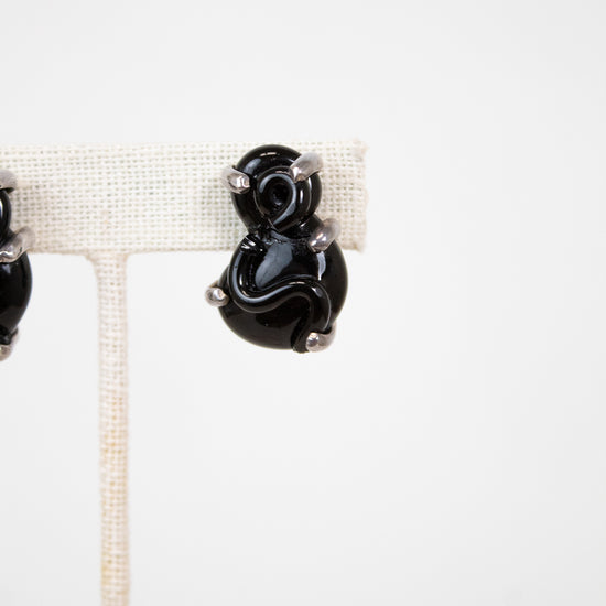 Black glass earrings on a white background