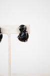 Black glass earrings on a white background