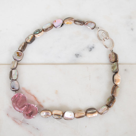 Necklace with multicolored beads on a marble surface