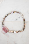 Necklace with multicolored beads on a marble surface