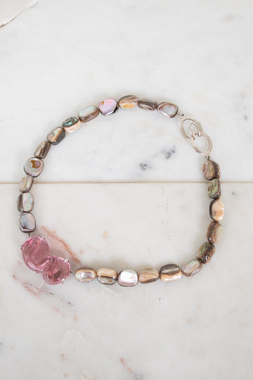 Necklace with multicolored beads on a marble surface