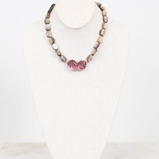 Necklace with mother of pearl beads on a white mannequin bust against a white background