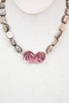 Necklace with pink glass bead and mother of pearl beads on a white background