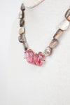 Necklace with pink beads and mother of pearl beads on a white background