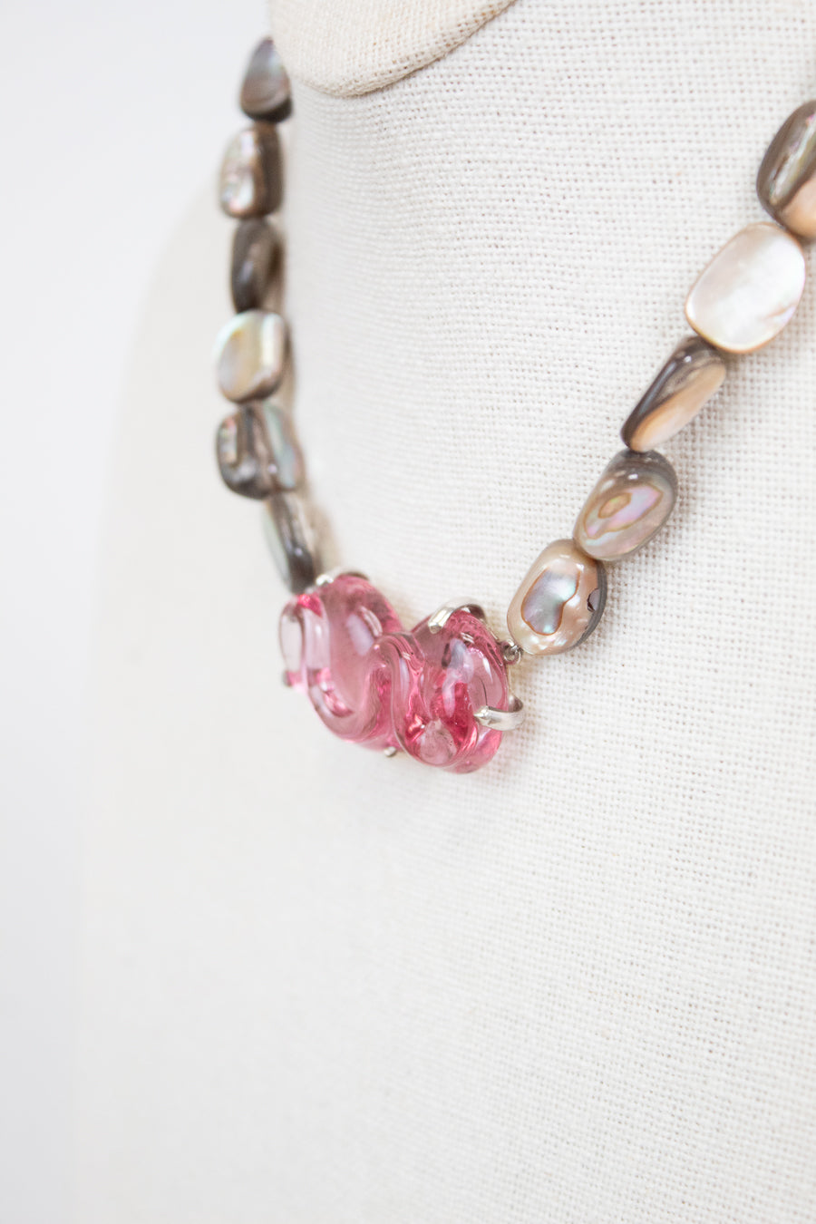 Necklace with pink beads and mother of pearl beads on a white background