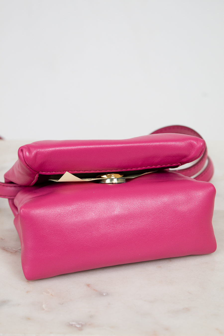 Pink handbag on a light marble surface