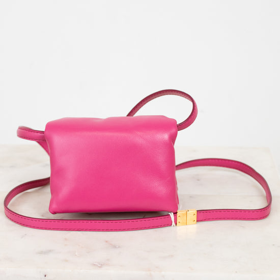 Pink leather crossbody bag on a light background