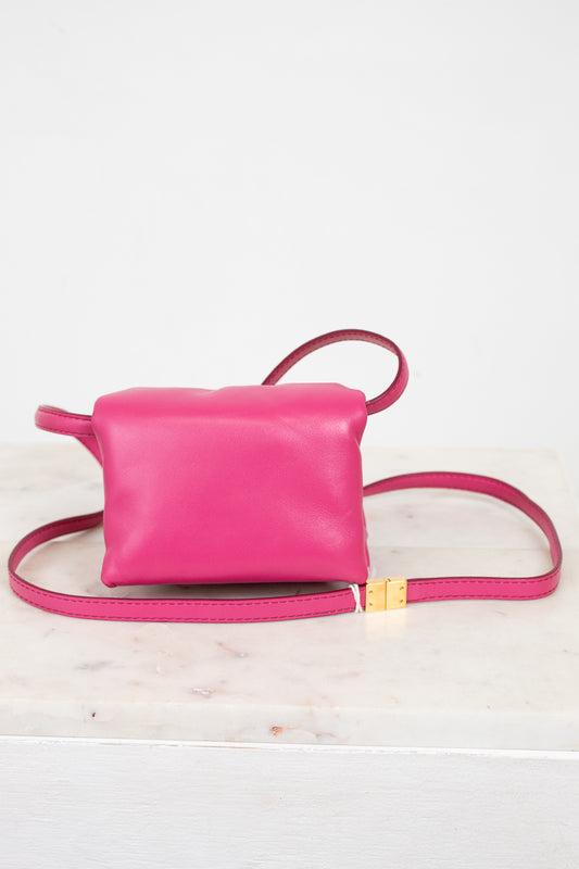 Pink leather crossbody bag on a light background