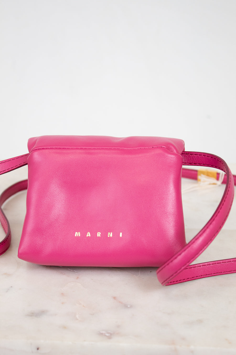 Pink handbag with 'Marni' branding on a marble surface