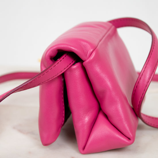 Side of pink handbag on a light background