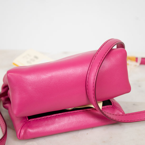 Pink handbag on a marble surface with a white background