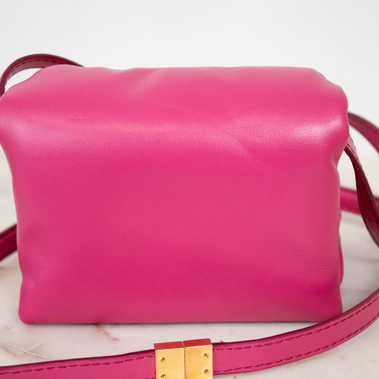 Pink handbag with a gold clasp on a light background