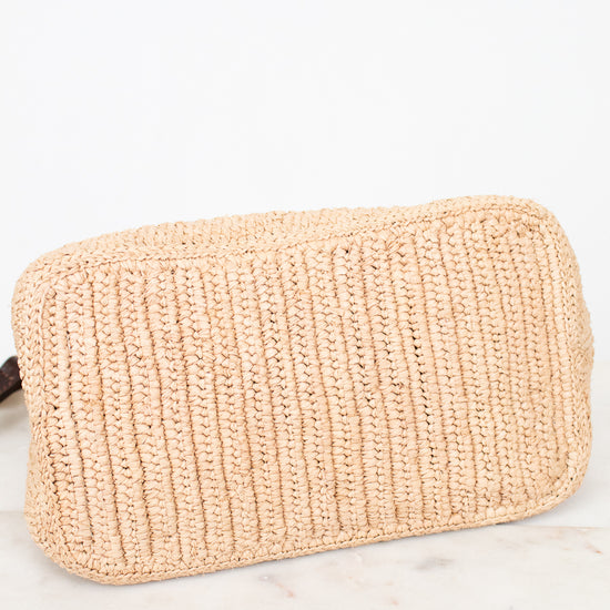 A light beige woven straw pouch with a ribbed texture, resting on a white marble surface against a white background.