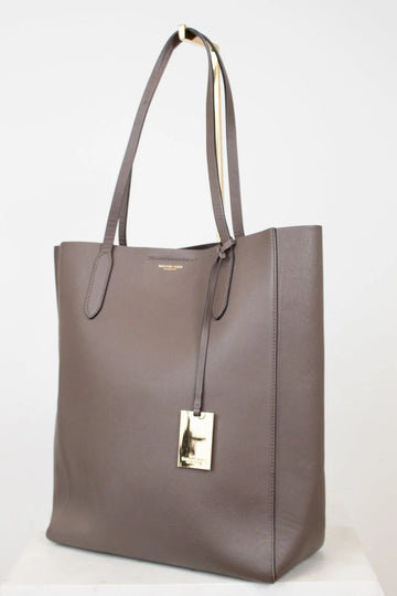 Brown tote bag with a gold tag on a white background