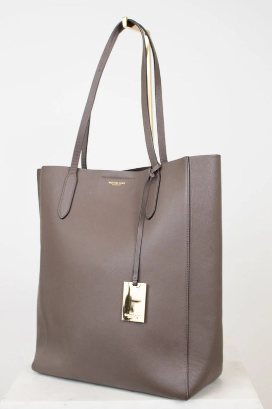 Brown tote bag with a gold tag on a white background